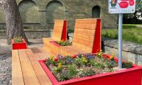 Bild vom Parklet - einer Sitzgelegenheit mit vielen Blumen in kleinen Beeten.