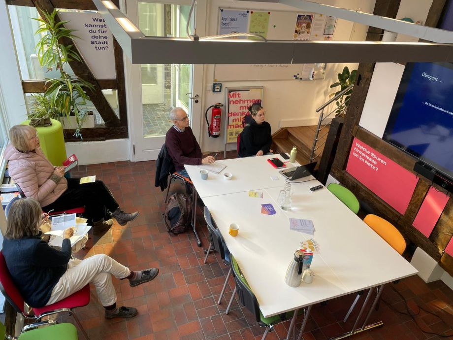 Menschen sitzen bei einer Veranstaltung im stadtLABOR und schauen auf den Bildschirm