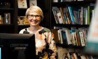 Portraitfoto von Enneke Siedler vor einem Bücherregal in einer Soester Buchhandlung.
