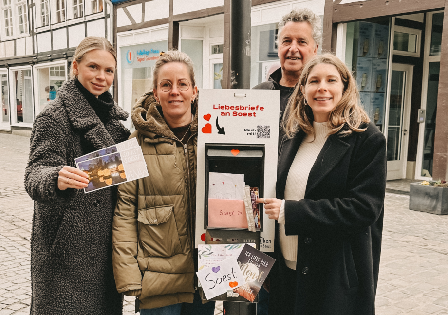 Team vom stadtLABOR, WMS, Stadt Soest und Schönes Soest stehen vor dem stadtLABOR und werfen einen Brief in den Liebesbriefkasten ein.