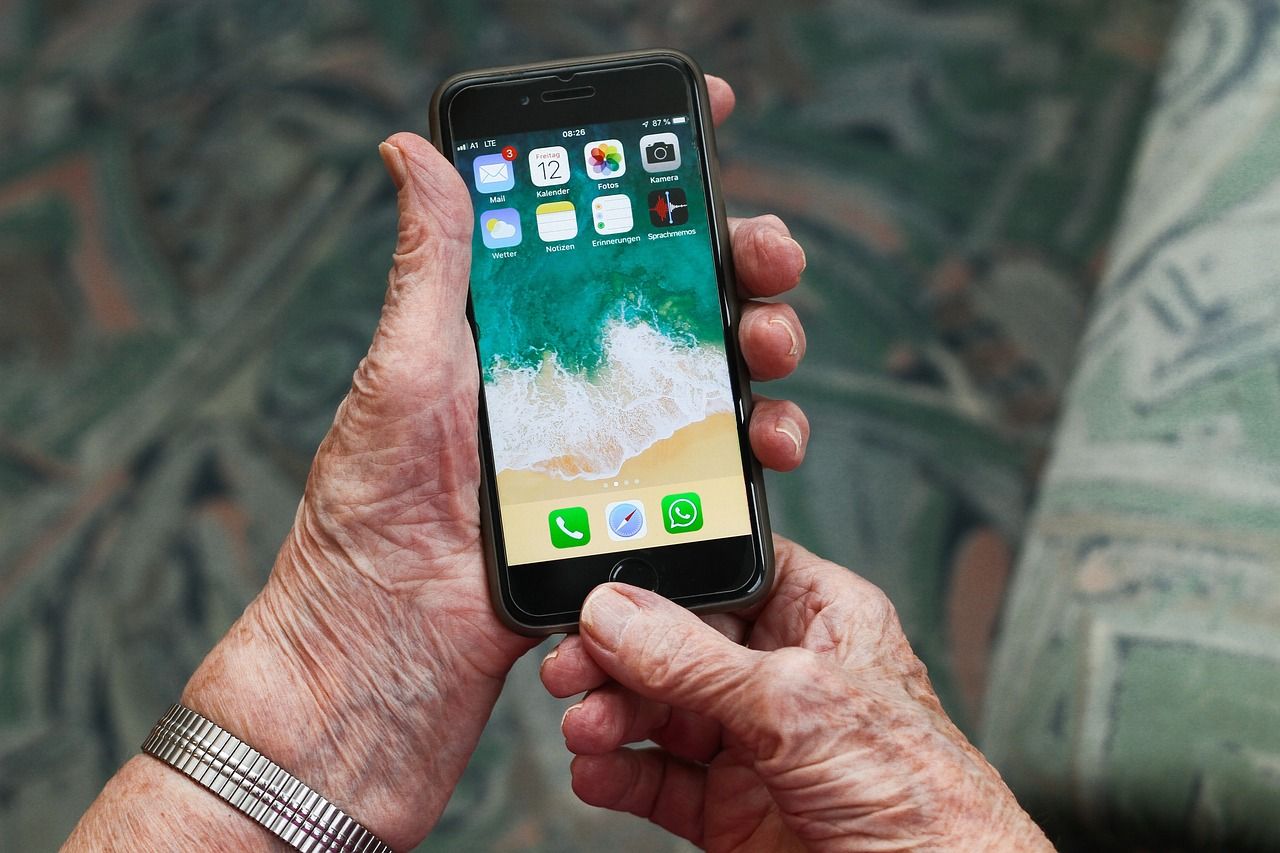 Ein Smartphone in der Hand einer Seniorin.