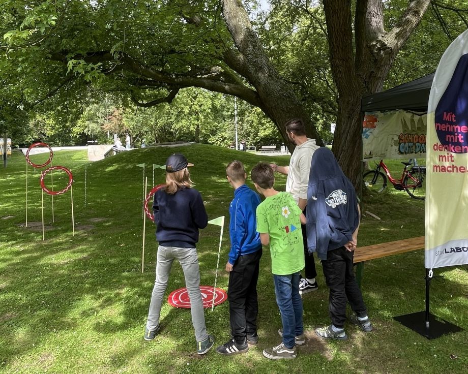 Kinder im Soester Stadtpark die eine Minidrohne durch einen Parcours fliegen lassen.