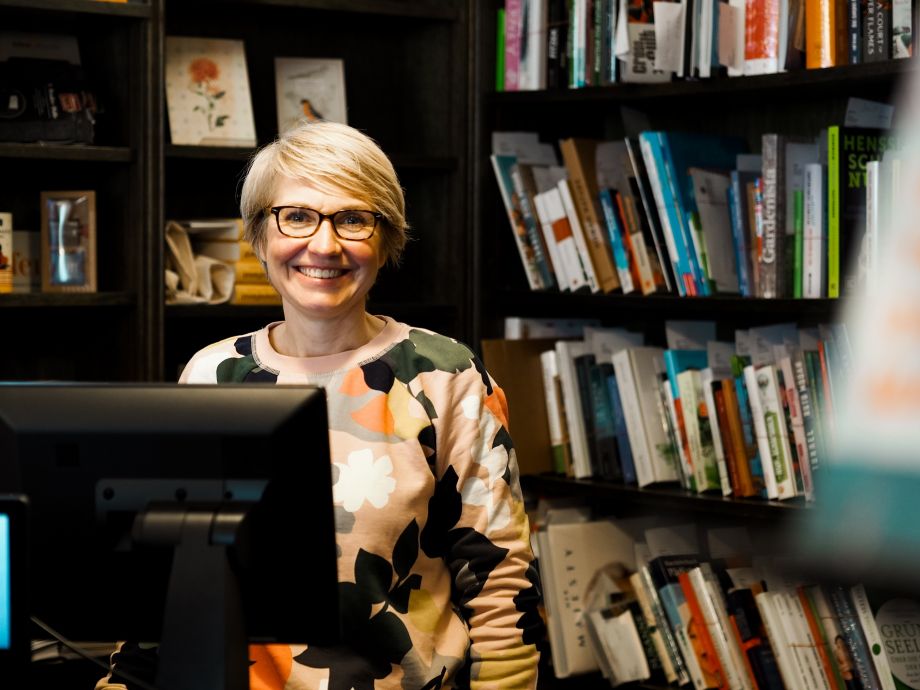 Portraitfoto von Enneke Siedler vor einem Bücherregal in einer Soester Buchhandlung.