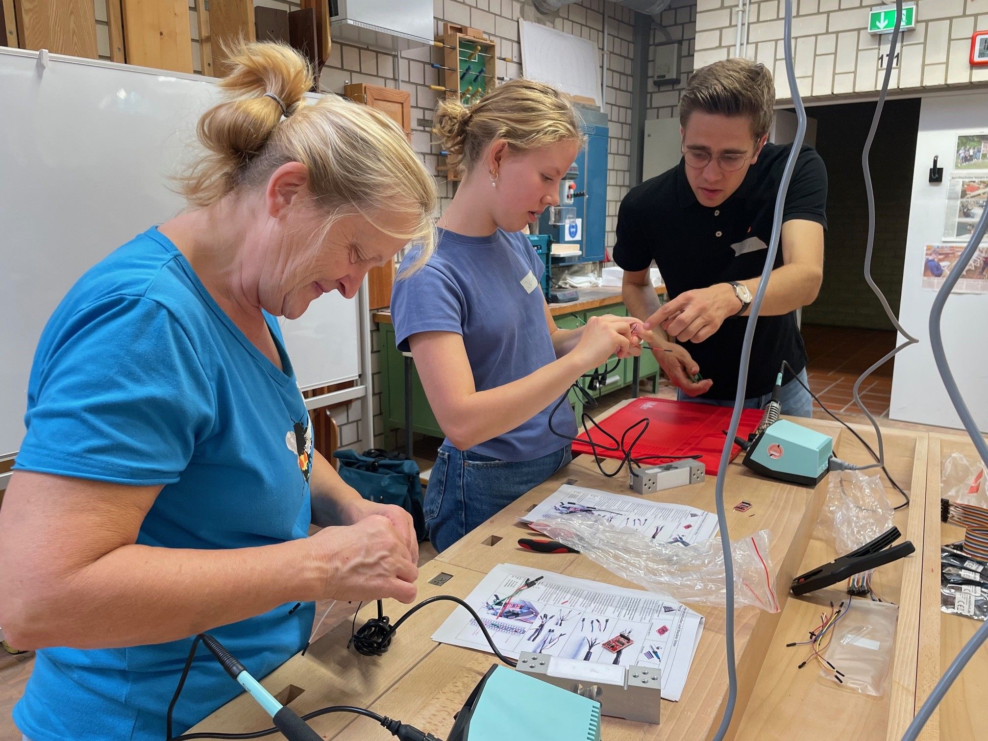 Drei Personen bauen in der Werkstatt an einem Digitalen Bienenstock