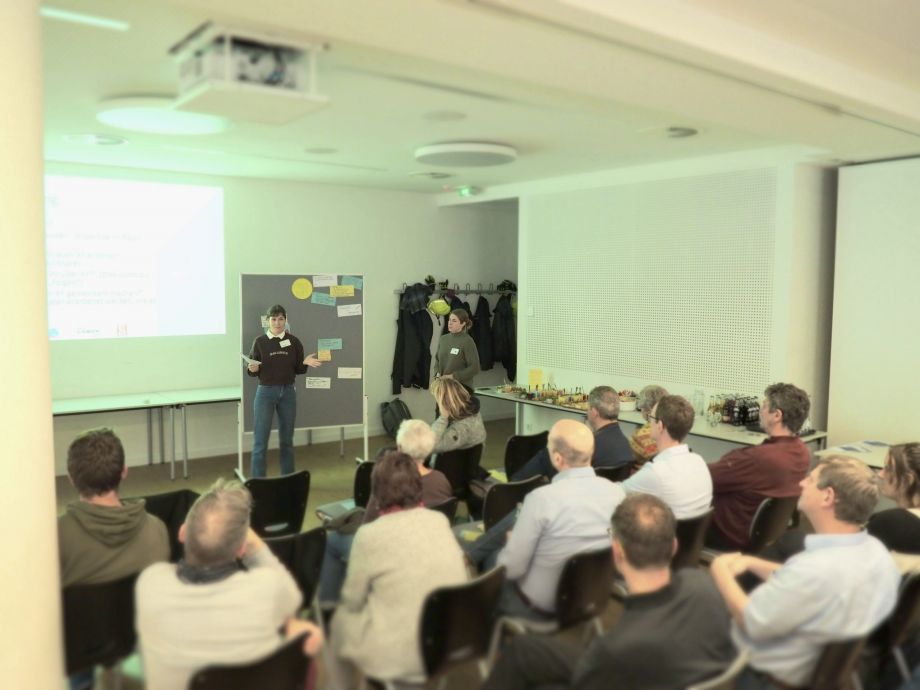 Eine Gruppen von Menschen sitzt beim 1. Klimaforum zusammen und blickt auf ein Whiteboard mit verschiedenen Ideenkarten zur Klimakrisenbewältigung in Soest.