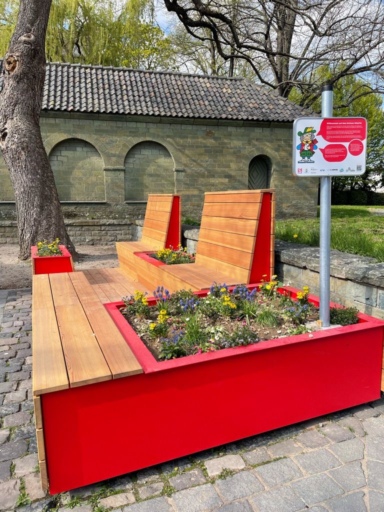 Bild vom Parklet - einer Sitzgelegenheit mit vielen Blumen in kleinen Beeten.