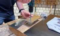 Nahaufnahme beim Schrauben in eine Metallplatte