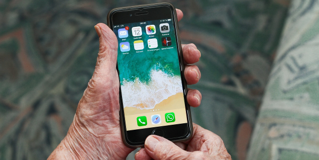 Ein Smartphone in der Hand einer Seniorin.