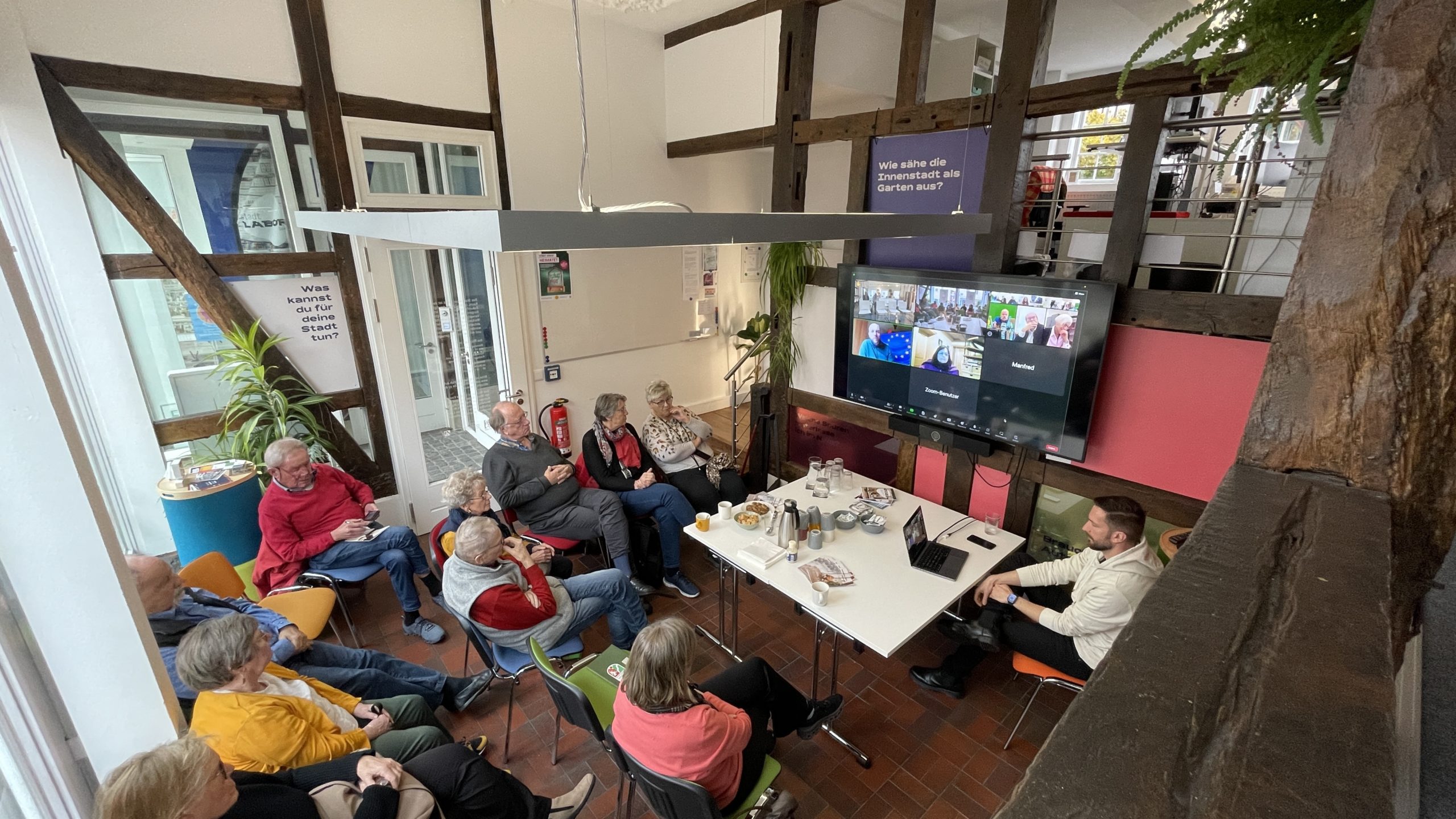 Eine Gruppe von Menschen sitzend im stadtLABOR, aus der Vogelperspektive fotografiert