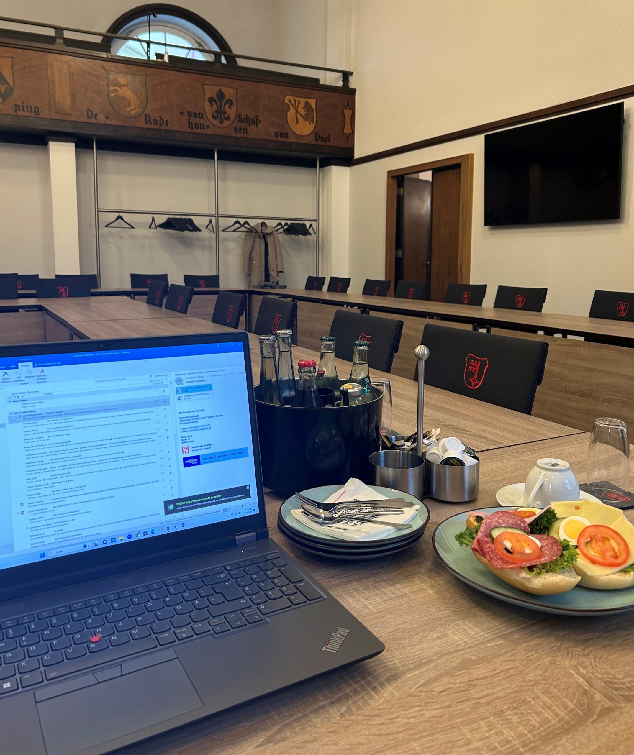 Das Bild zeigt im Vordergrund einen Laptop im Ratssaal des Rathauses Soest.