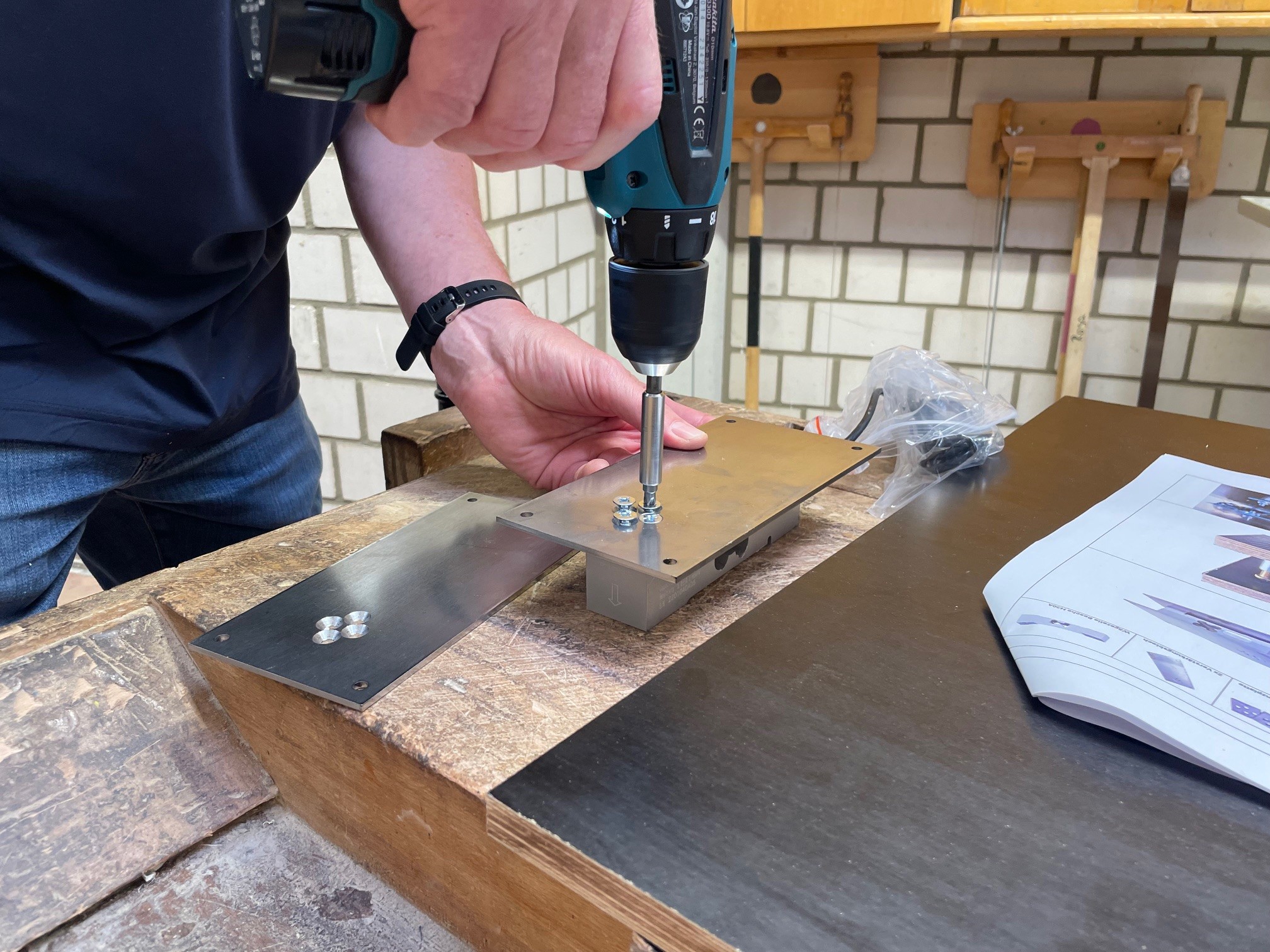 Nahaufnahme beim Schrauben in eine Metallplatte
