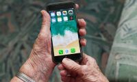 Ein Smartphone in der Hand einer Seniorin.