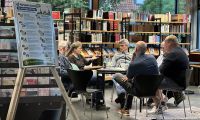 Eine Gruppe sitzt in der Stadtbücherei und diskutiert über ein Thema.